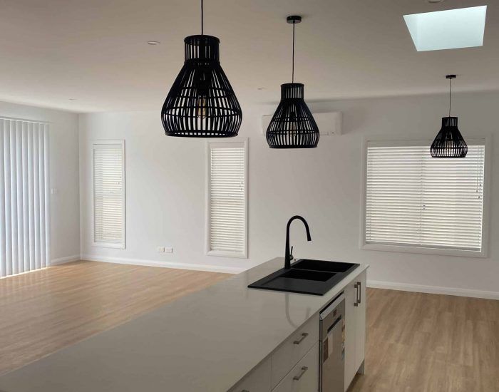 A Kitchen with White Cabinets , a Sink , and A Skylight — Bay Blinds & Doors in Umina Beach, NSW