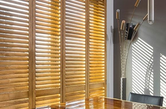 A Room with White Shutters on The Doors and A Picture on The Wall — Bay Blinds & Doors in Bateau Bay, NSW