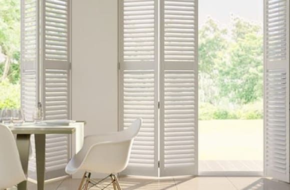 A Room with White Shutters on The Doors and A Picture on The Wall — Bay Blinds & Doors in Bateau Bay, NSW