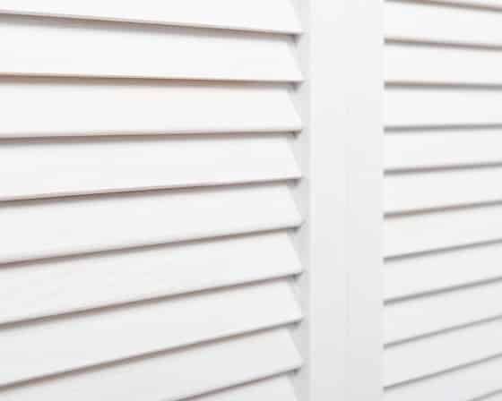A Close up Of a Pair of White Shutters on A Window — Bay Blinds & Doors in Gosford, NSW