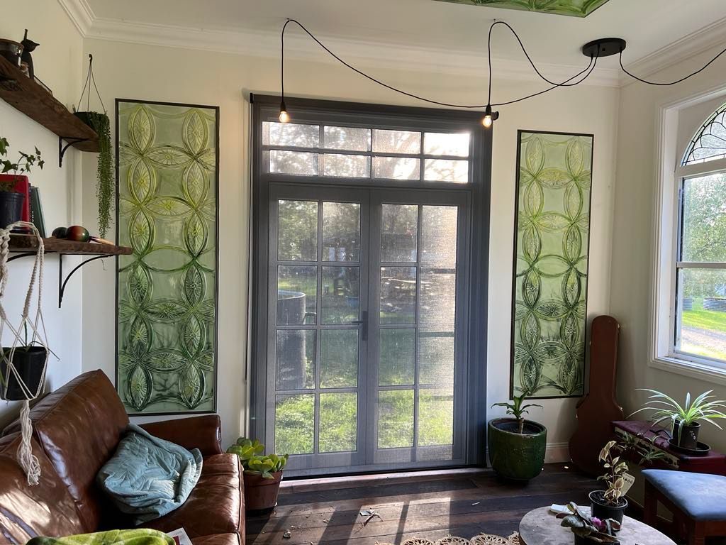 A Gray and White Striped Roman Shade Is Hanging on A Window — Bay Blinds & Doors in Woy Woy, NSW