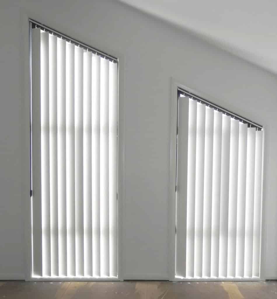 A Gray and White Striped Roman Shade Is Hanging on A Window — Bay Blinds & Doors in Berkeley Vale, NSW