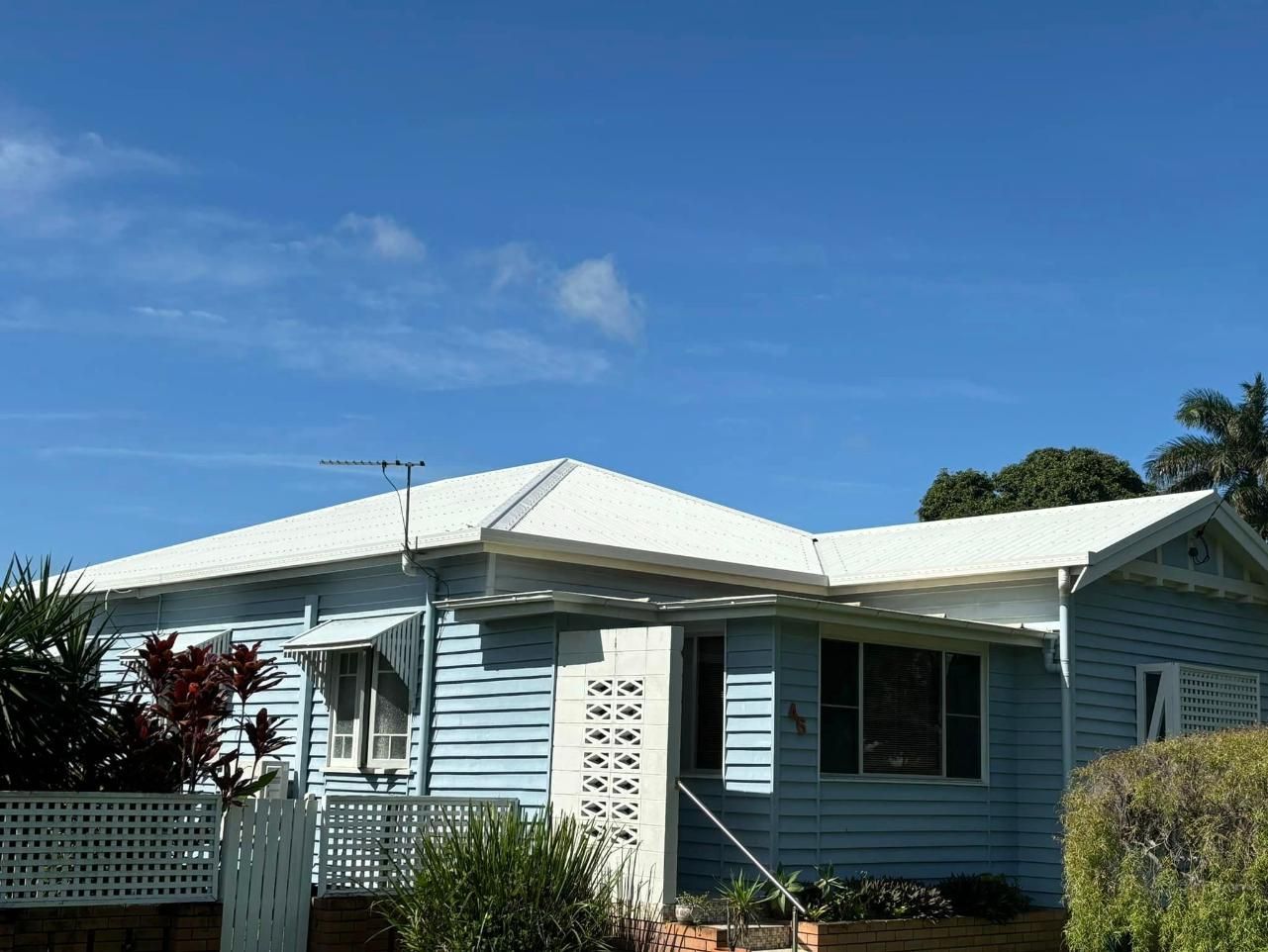 A Blue House With a White Roof and a White Fence — Geiger Solutions In Mackay, QLD