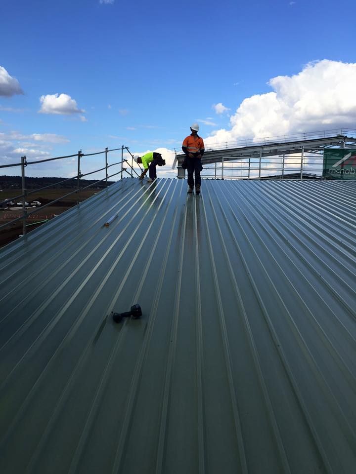 Two Men Are Working on the Roof of a Building — Geiger Solutions In Mackay, QLD