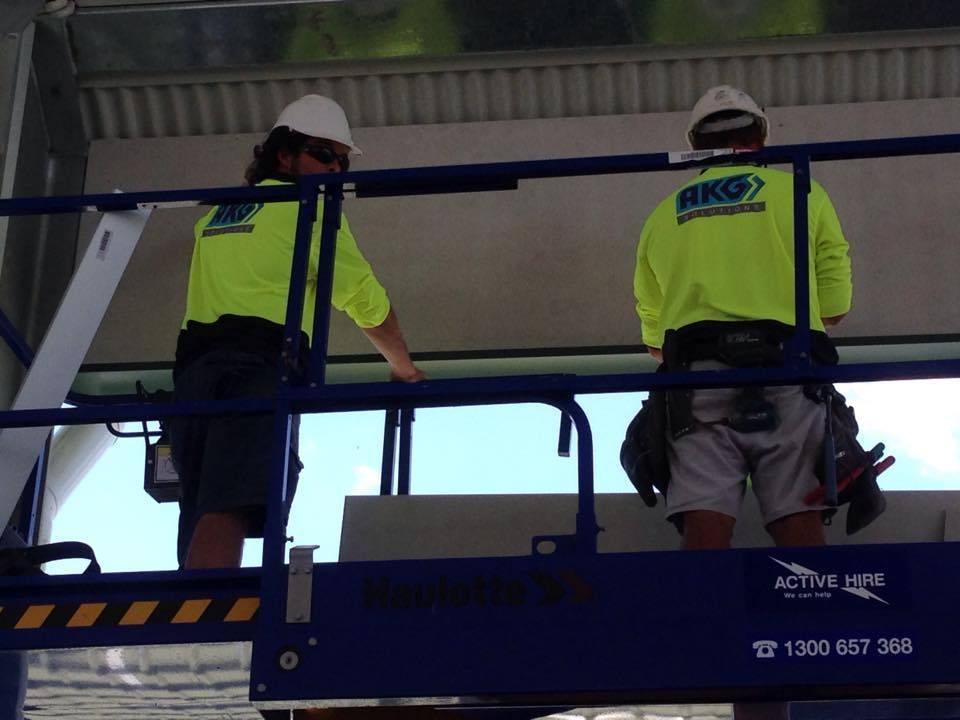 A Man Wearing a Yellow Shirt That Says Akg on the Back — Geiger Solutions In Moranbah, QLD