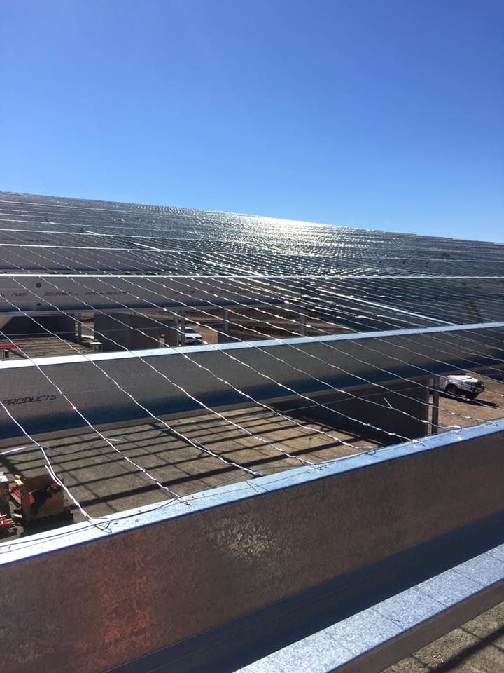 A Row of Solar Panels Are Sitting on Top of a Building — Geiger Solutions In Moranbah, QLD