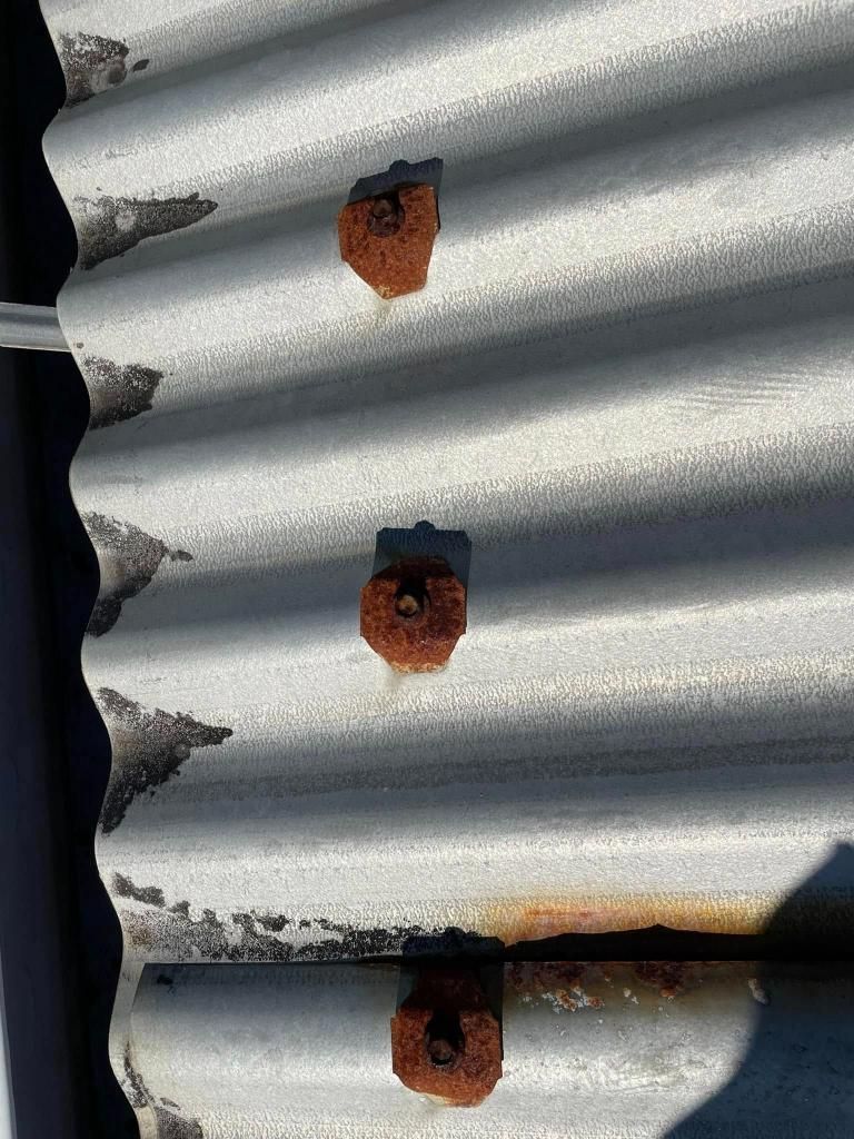 A Close Up of a Rusty Metal Roof With Holes in It — Geiger Solutions In Mackay, QLD