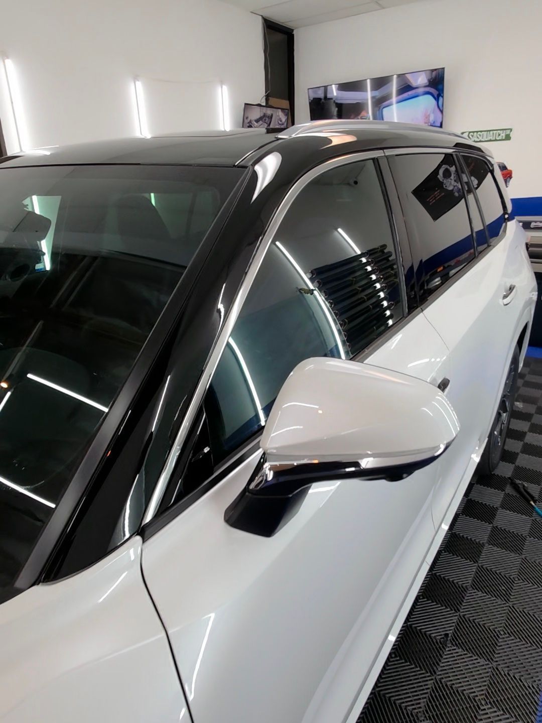 A white car with black trim is parked in a garage.