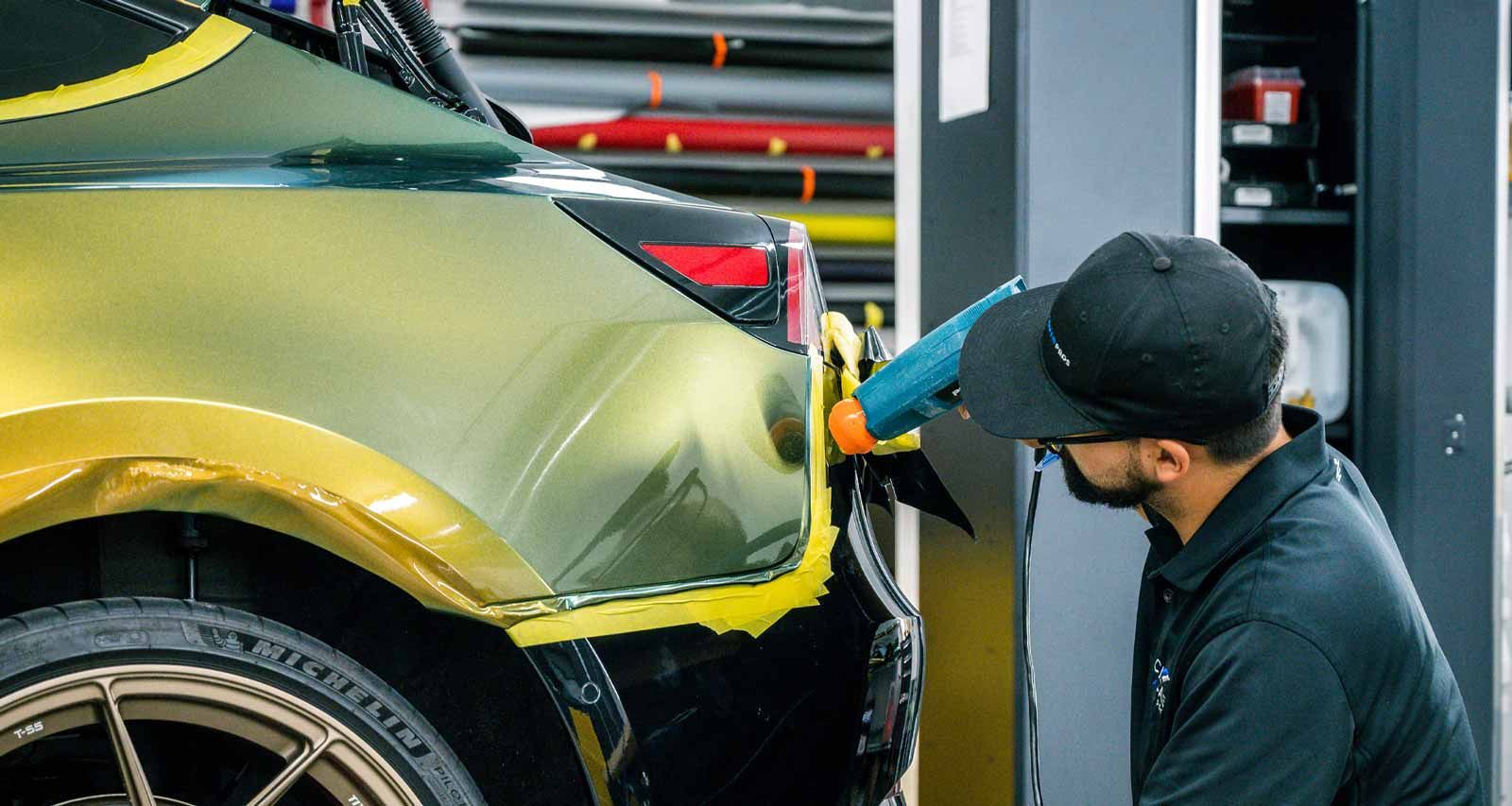 A man is working on a car in a garage.