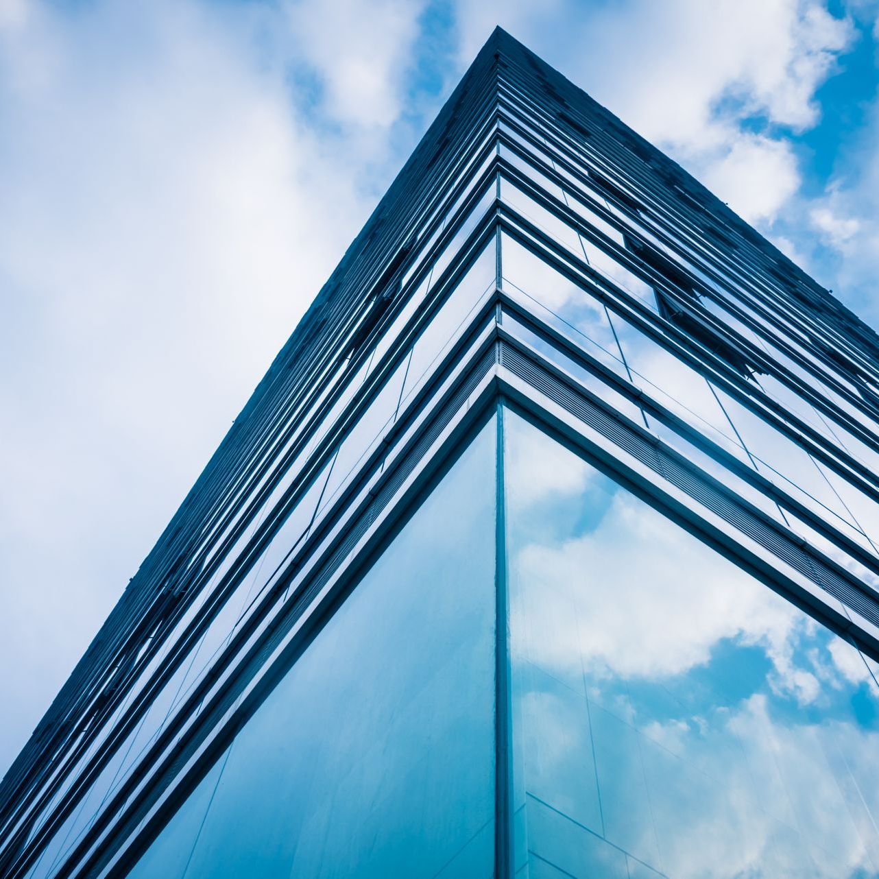 Looking up at the corner of a building with a blue sky in the background.