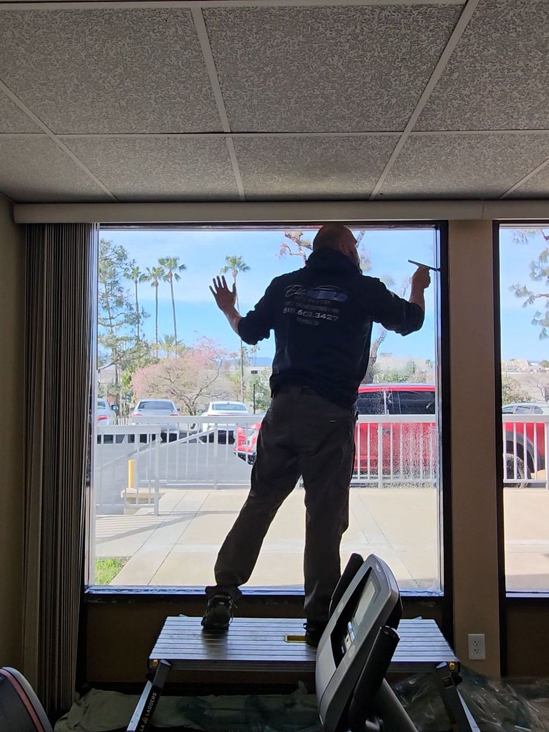 A man is standing in front of a window in a room.