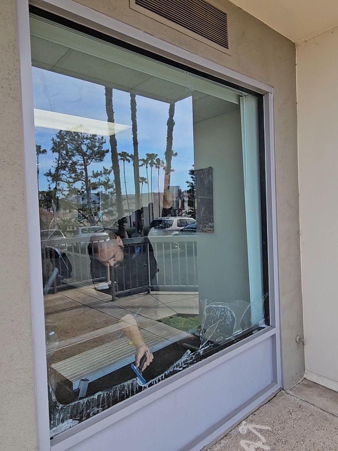 A person is standing in front of a large window.