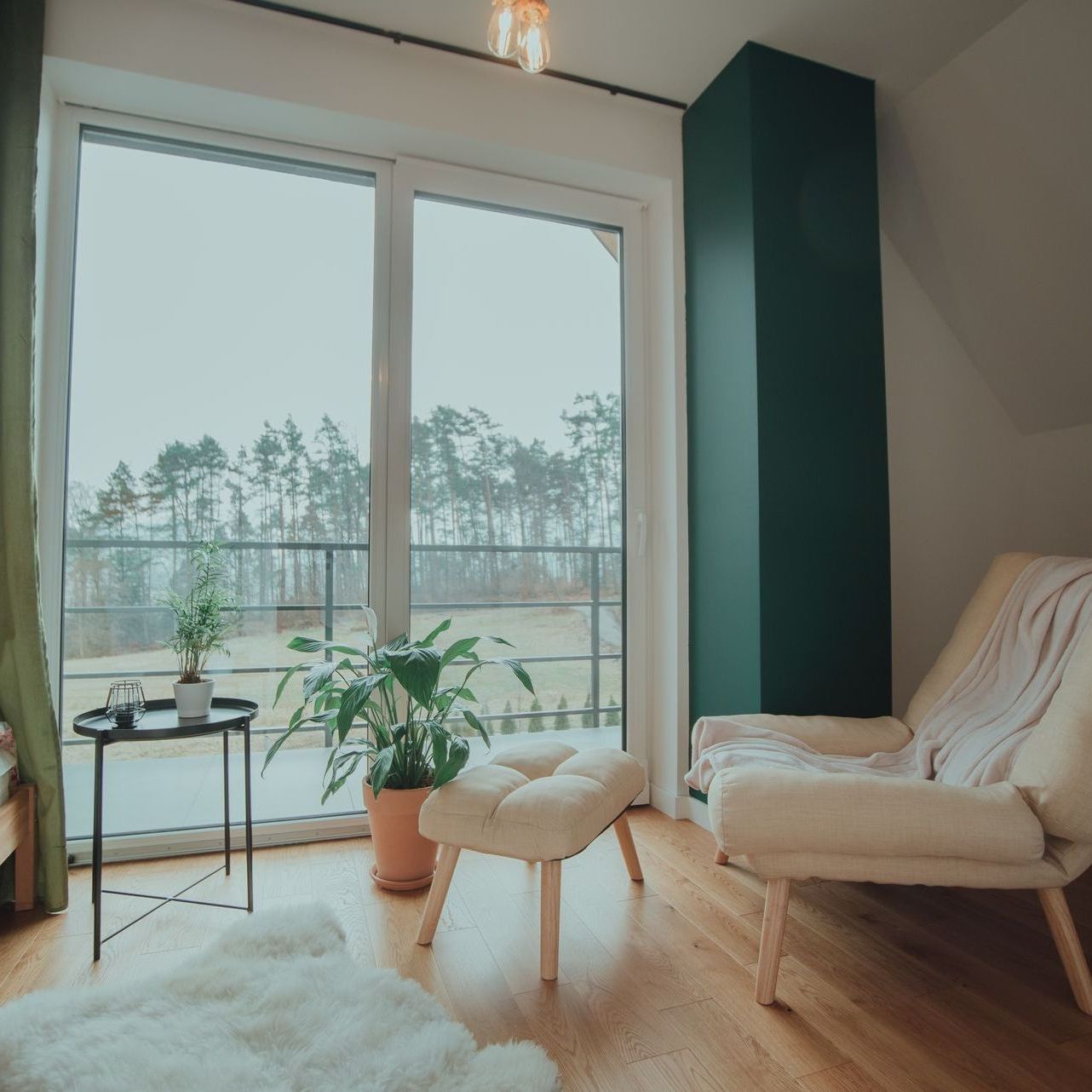 A living room with a chair and ottoman in front of a large window