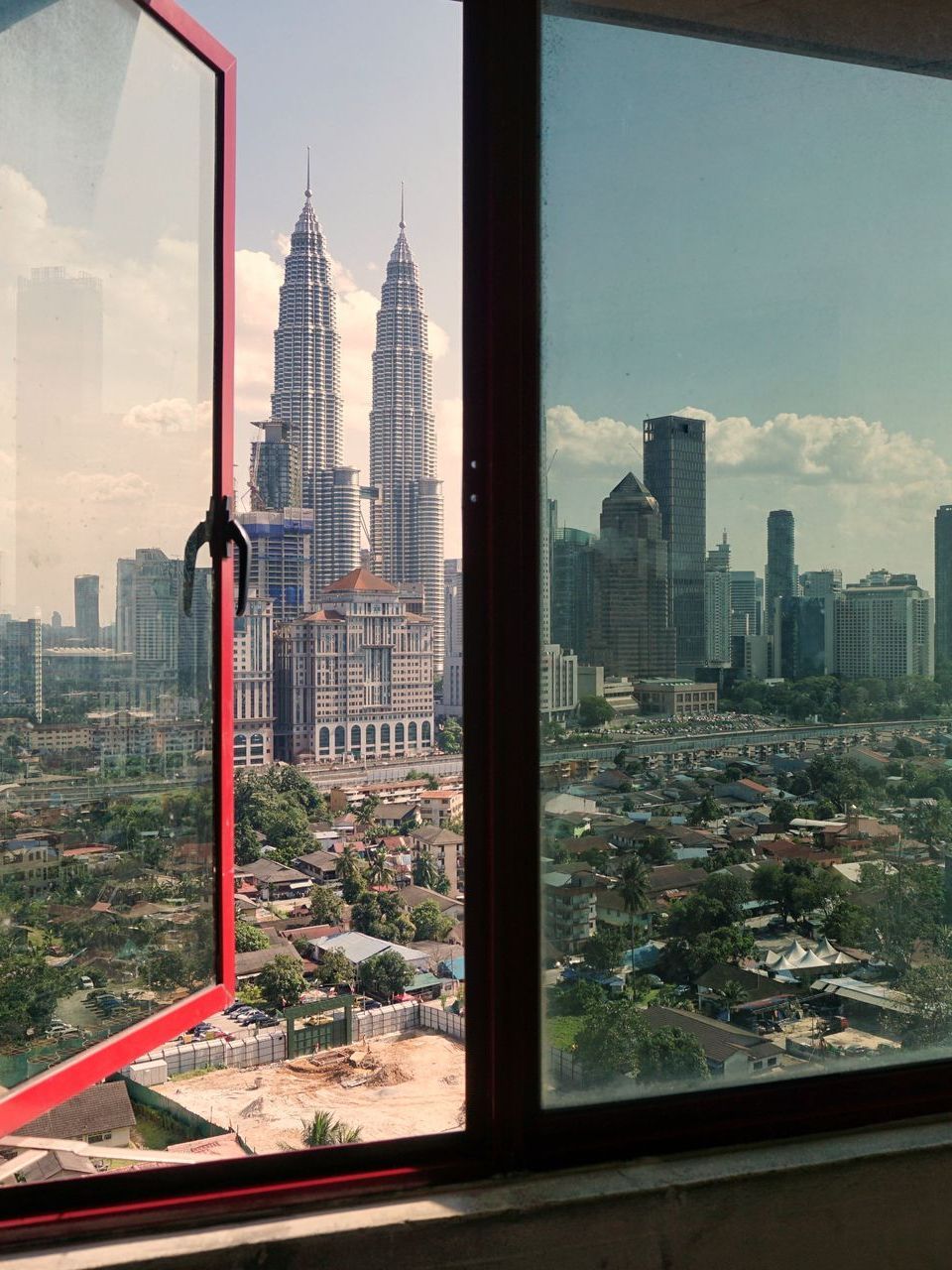 A view of a city from a window with a red frame