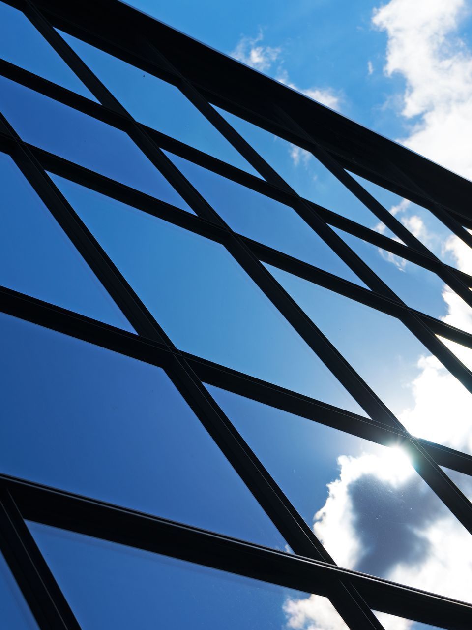 Looking up at a blue sky through a fence