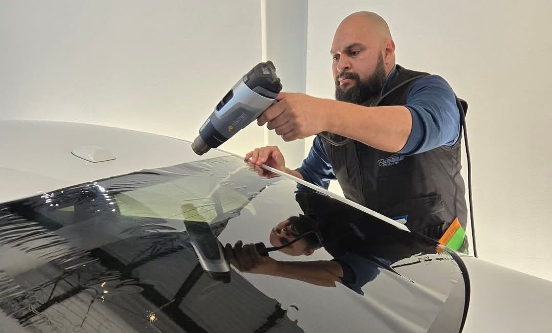 A car is being washed with foam in a garage.