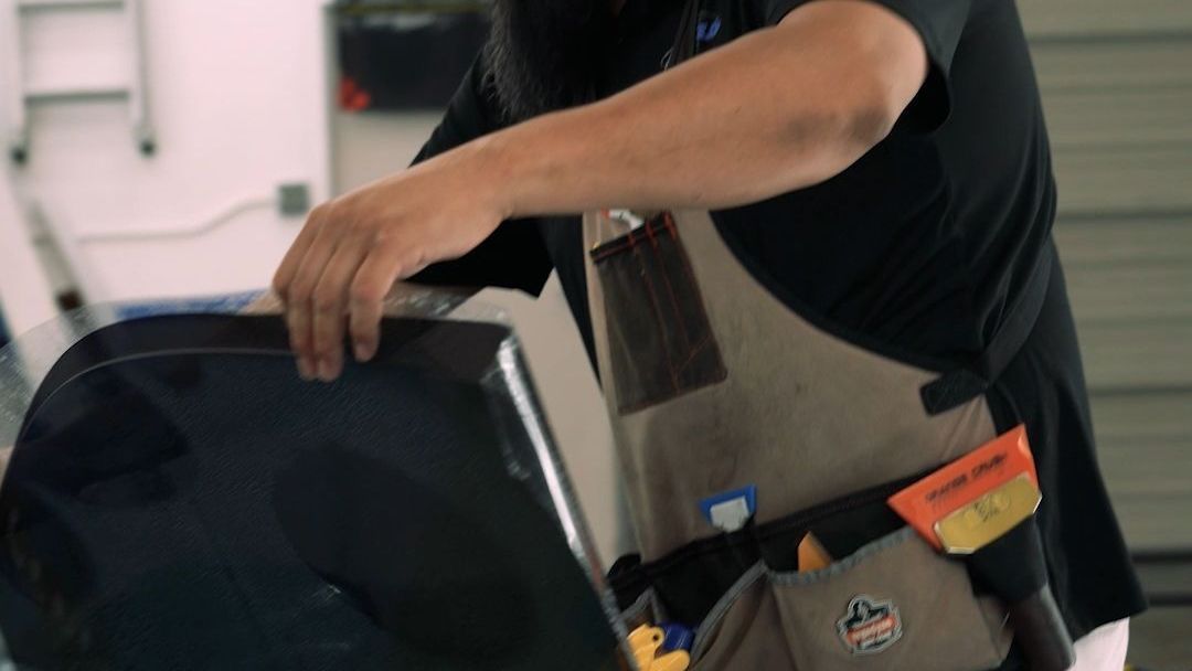 A man in an apron is working on a piece of equipment.