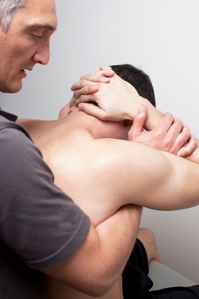 Physiotherapist adjusting a patient's neck. White background.