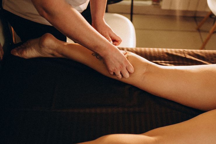 A woman receiving arm therapy from a person in a medical setting.