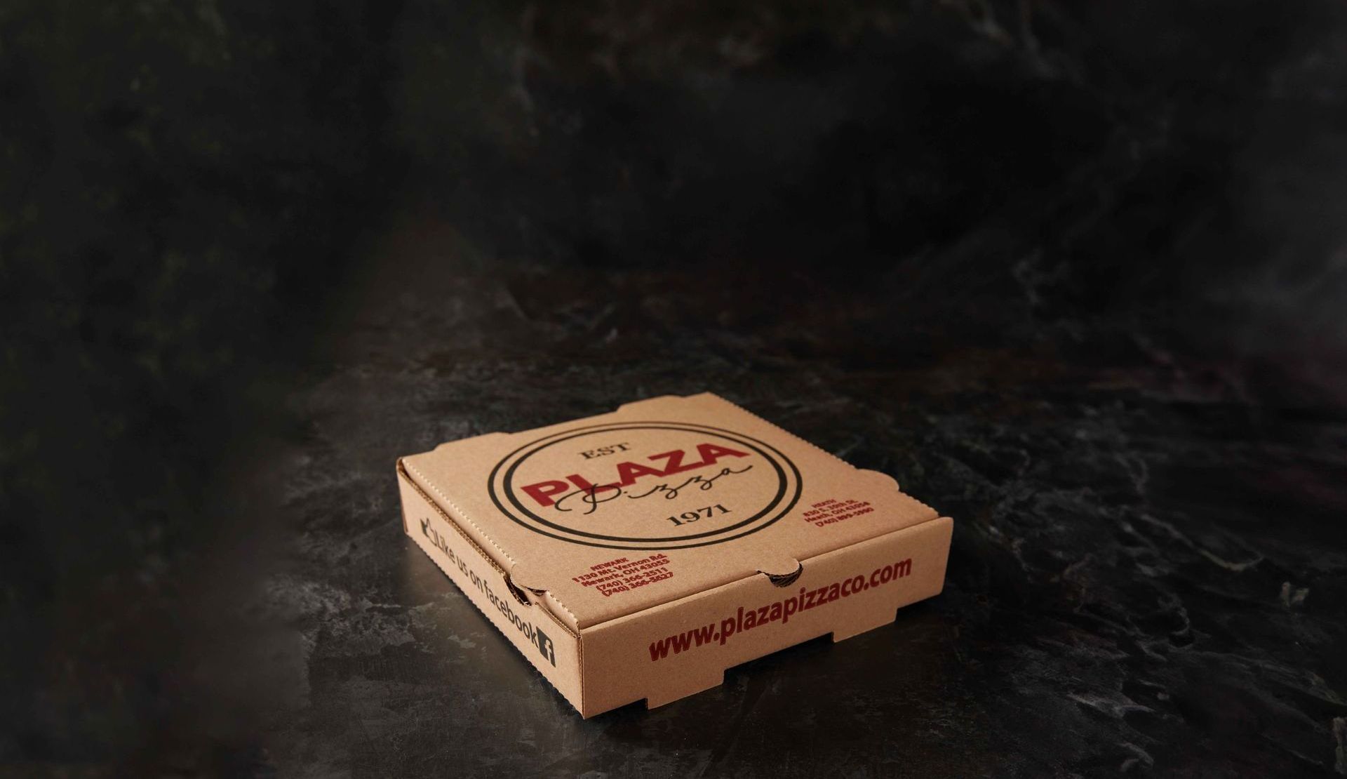 A plaza pizza box is sitting on a table.