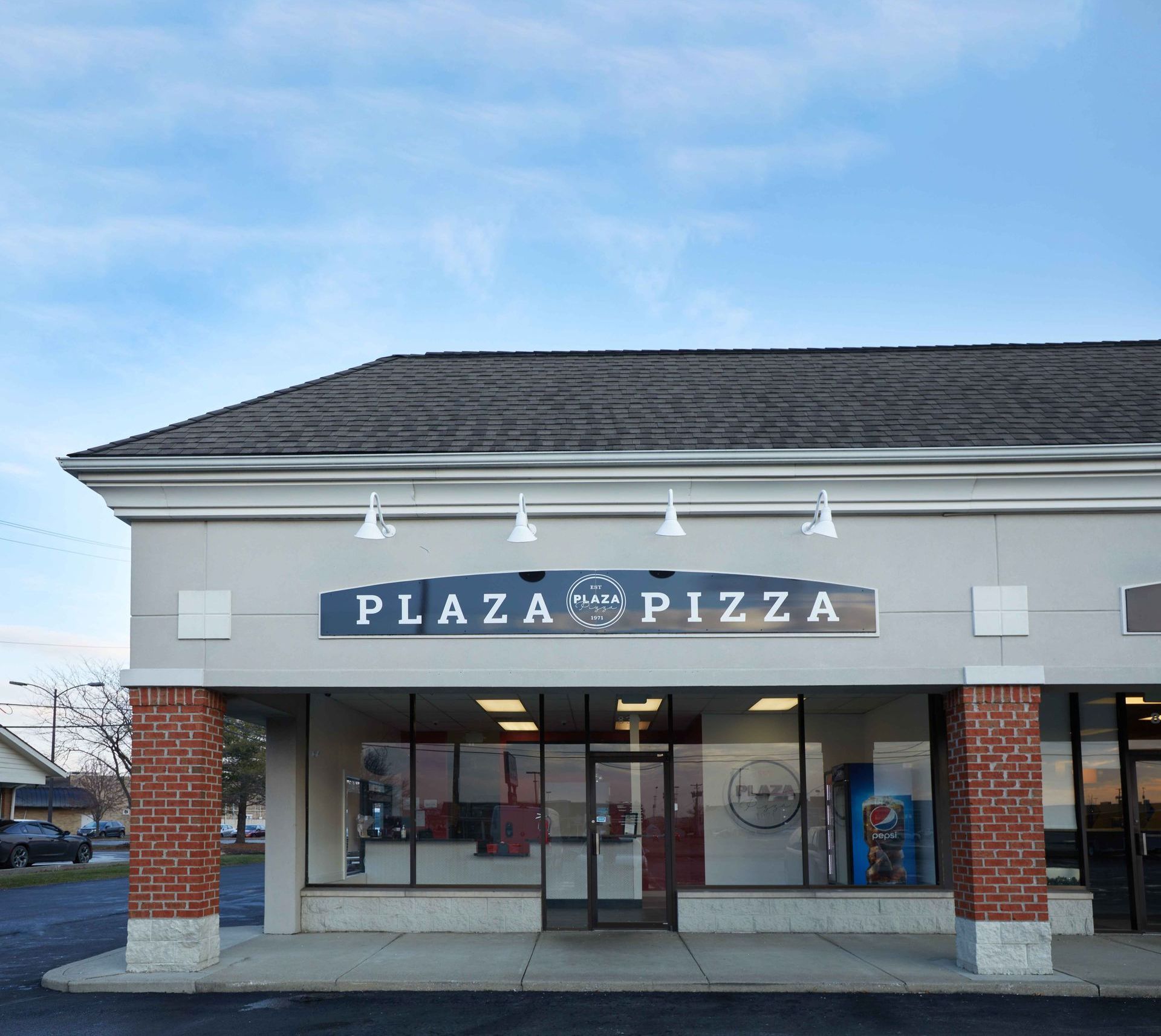 The front of plaza pizza with a blue sign