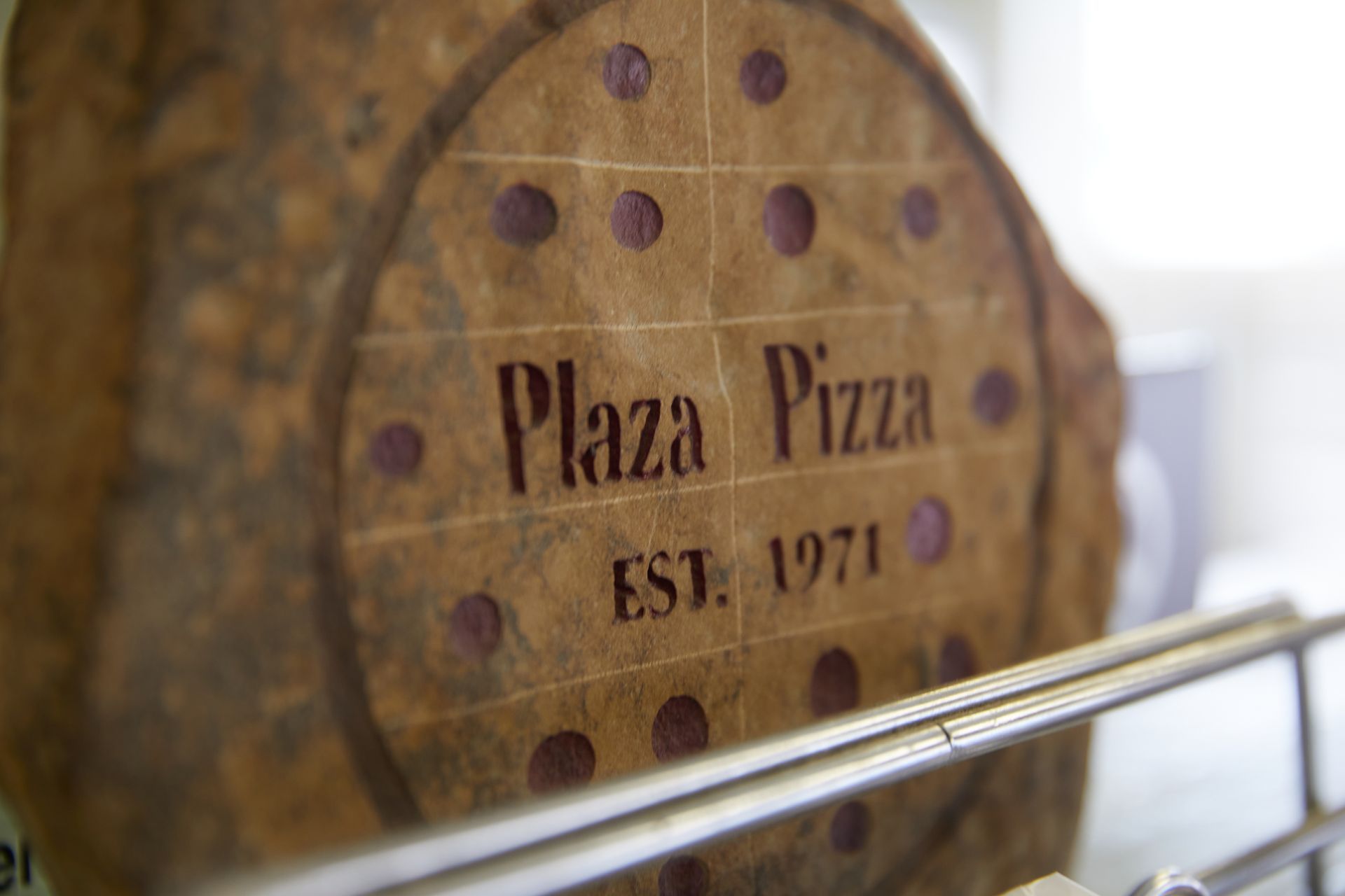 A close up of a pizza that says plaza pizza on it