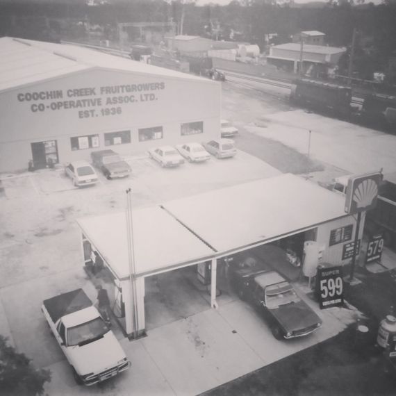 Black and white photo of a Shell gas station in front of a building with the words 