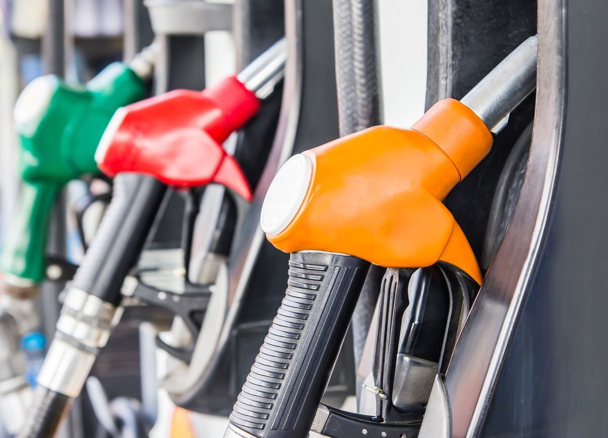 A row of gas pumps with different colors on them