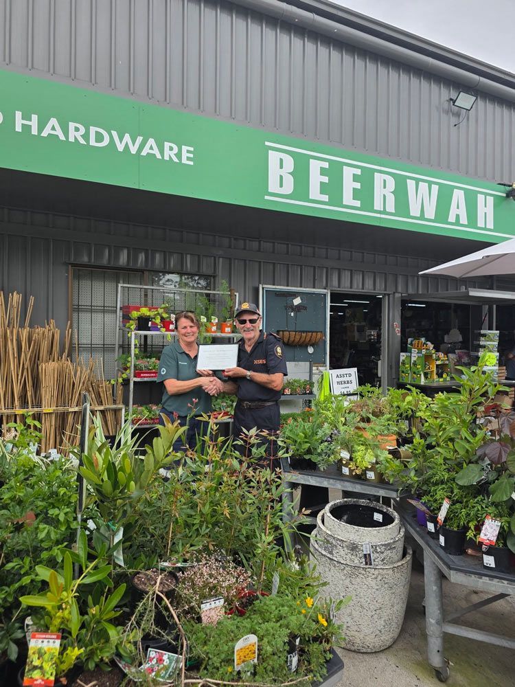 People Standing Outside Rural Supplies Shop