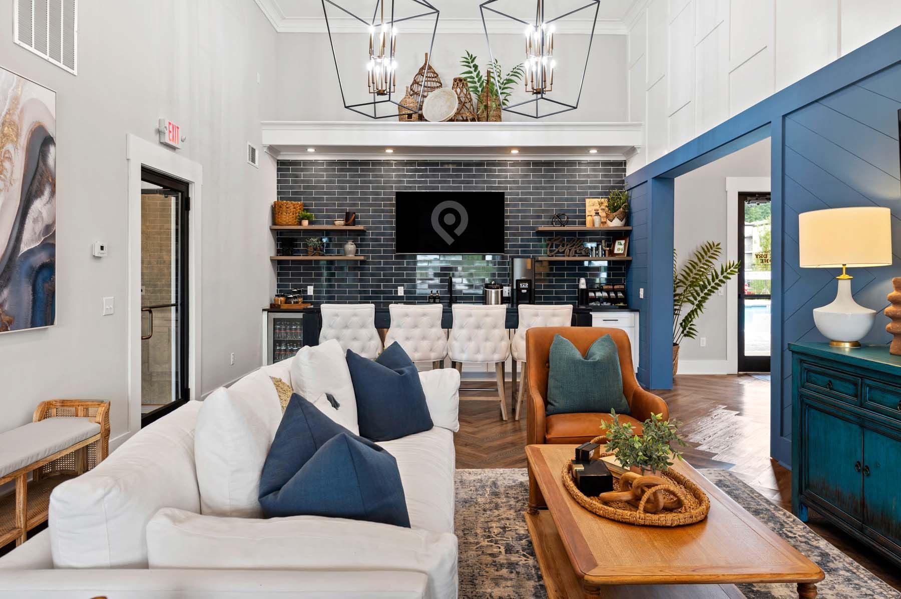 Clubhouse with a couch, chair, coffee table, and television at Pointe Grand Columbia apartments in Columbia, SC.