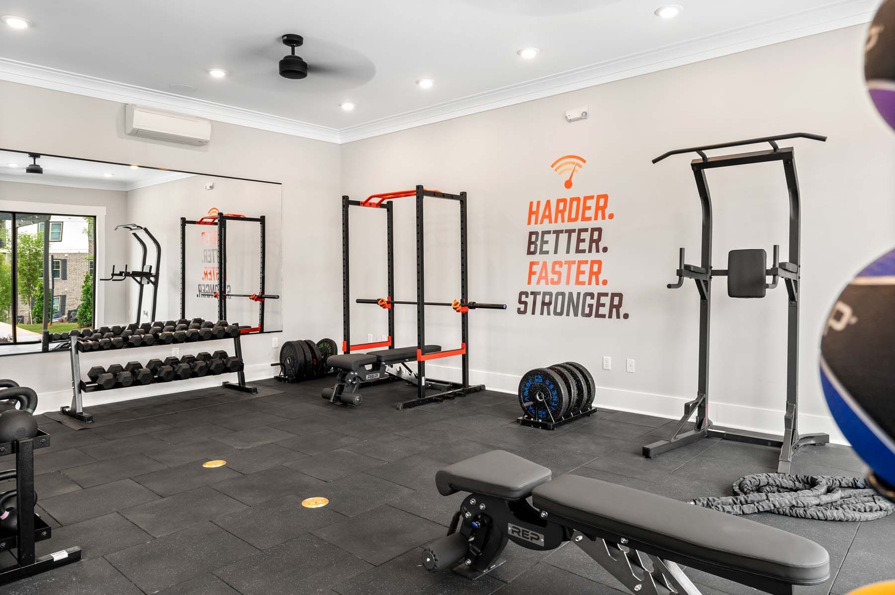 A gym with a bench, dumbbells, and a ceiling fan at Pointe Grand Columbia apartments in Columbia, SC.