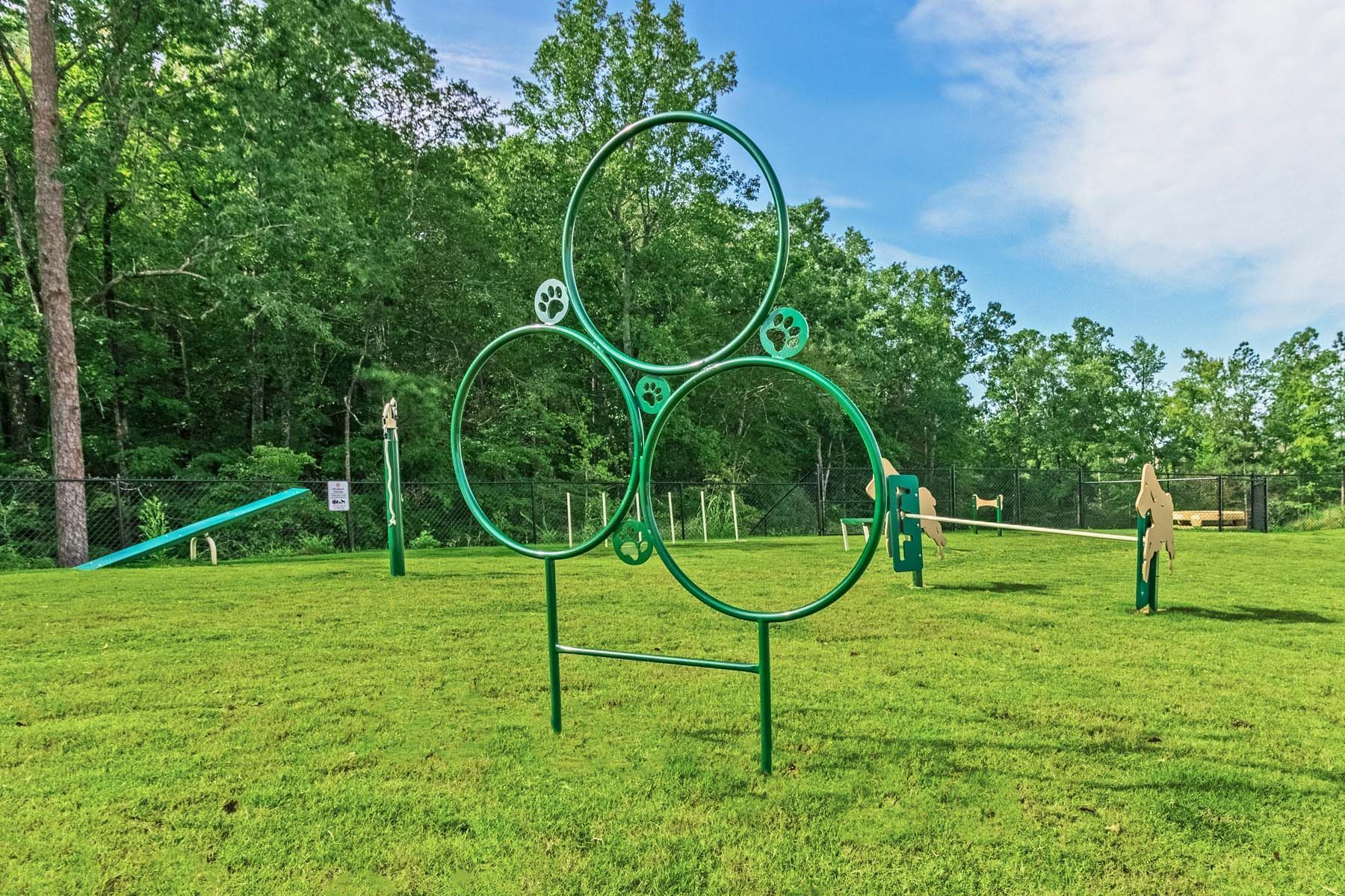 A dog park with a lot of green rings in the grass at Pointe Grand Columbia apartments in Columbia, SC.