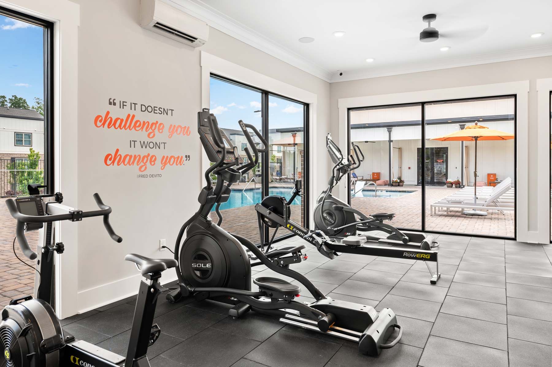 A gym with a lot of exercise equipment and a quote on the wall at Pointe Grand Columbia apartments in Columbia, SC.