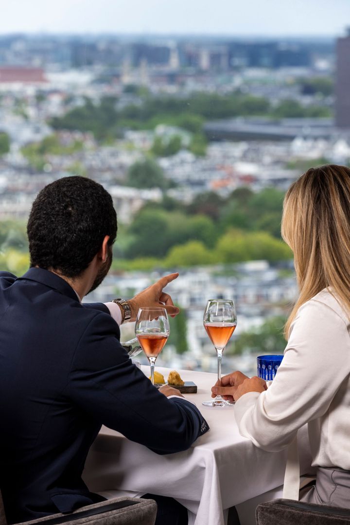 A telescope is sitting on a tripod overlooking a city.