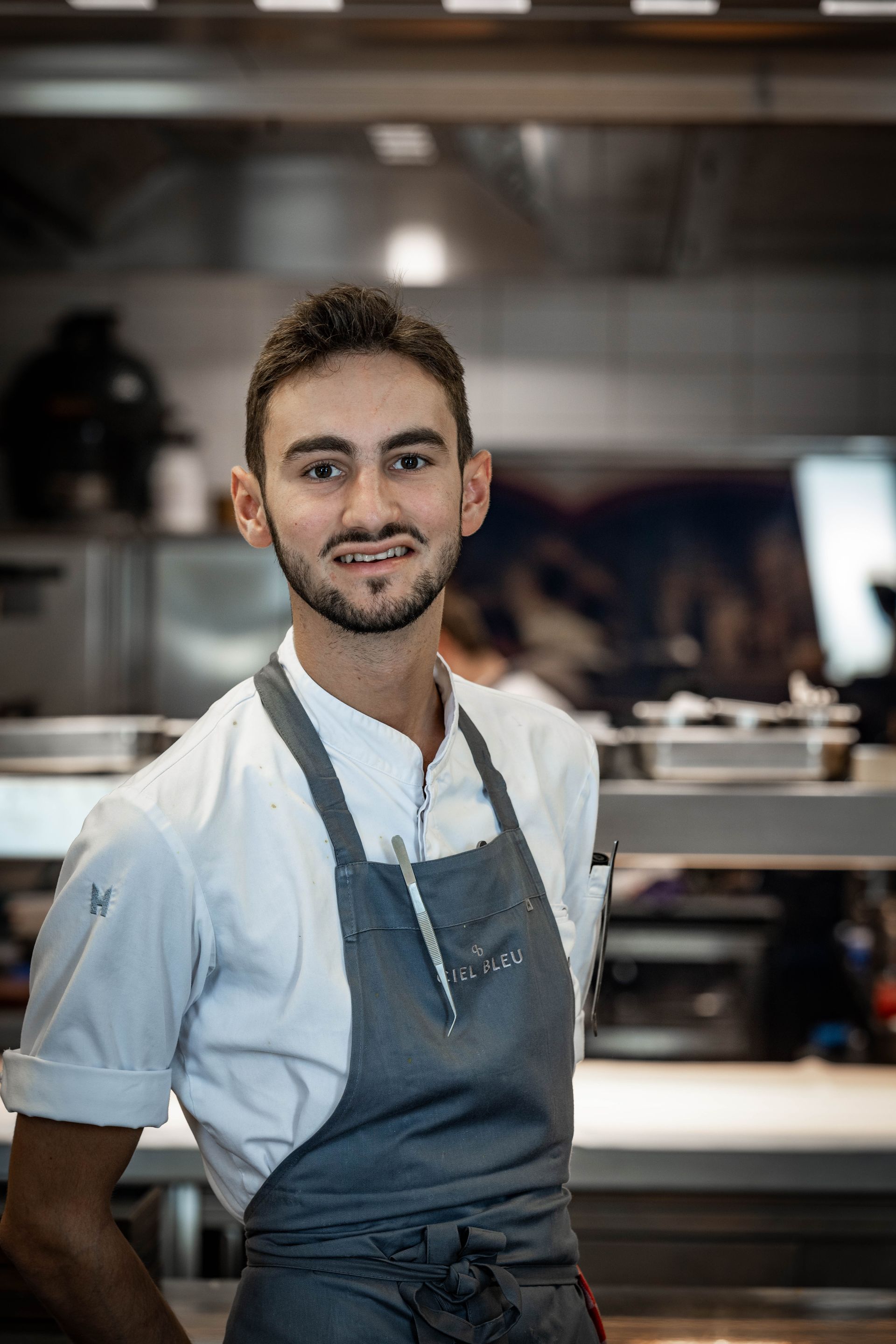 Een man met een schort staat in de keuken.