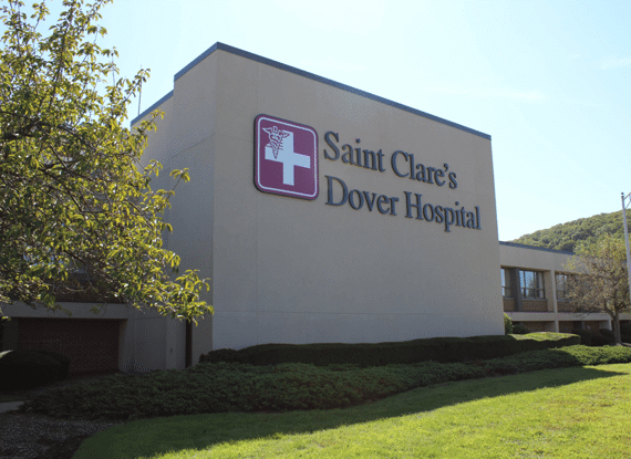 Saint Clare's Dover Hospital building with logo on a sunny day.