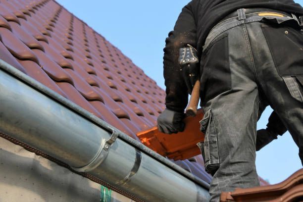A man is working on a roof with a hammer