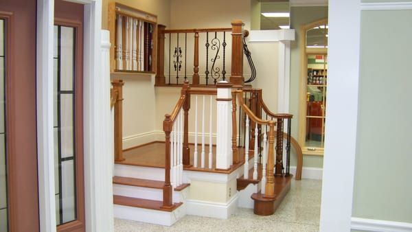 A wooden staircase with a white railing in a room