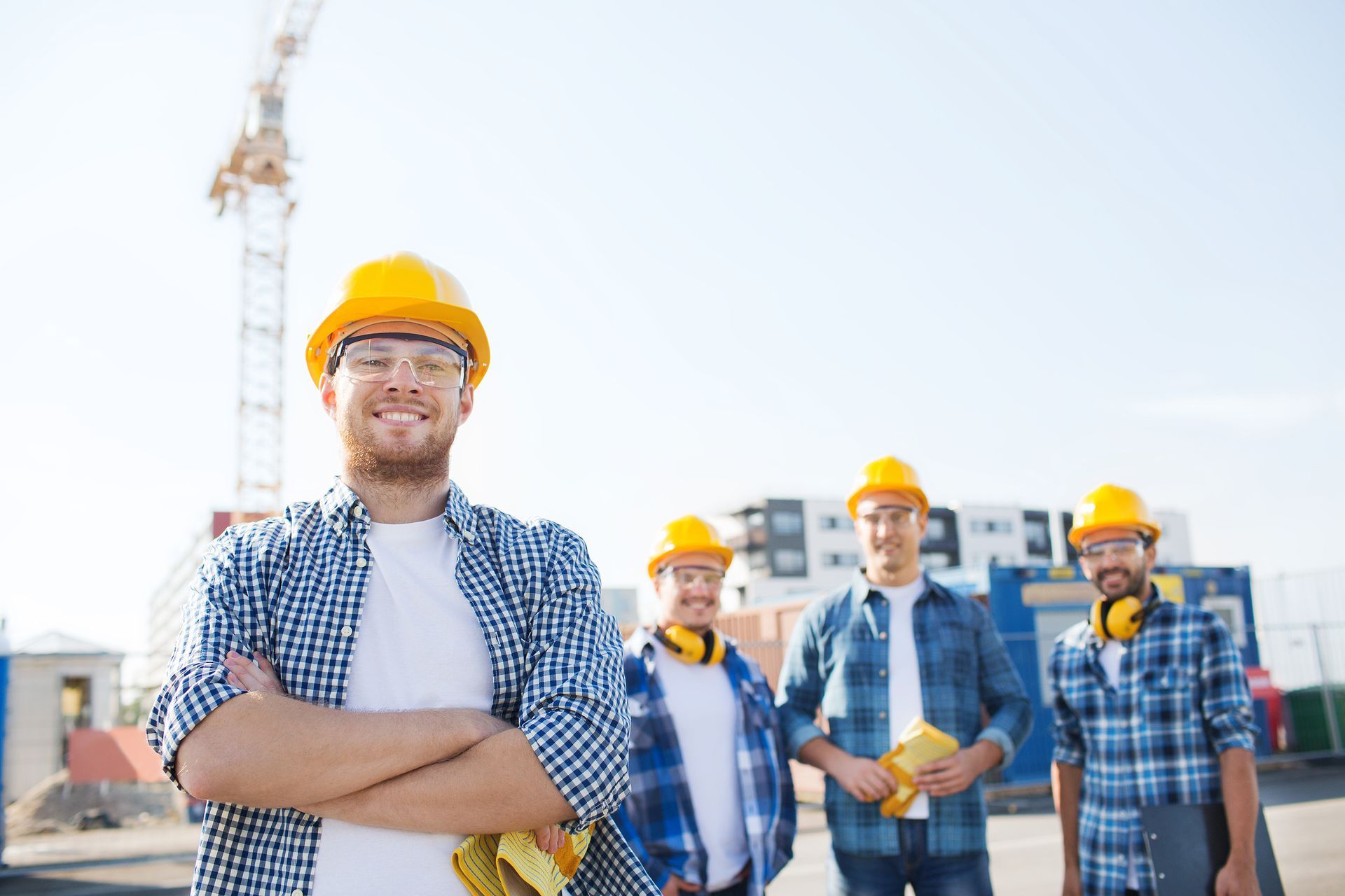 A group of construction workers are posing for a picture at a construction site.