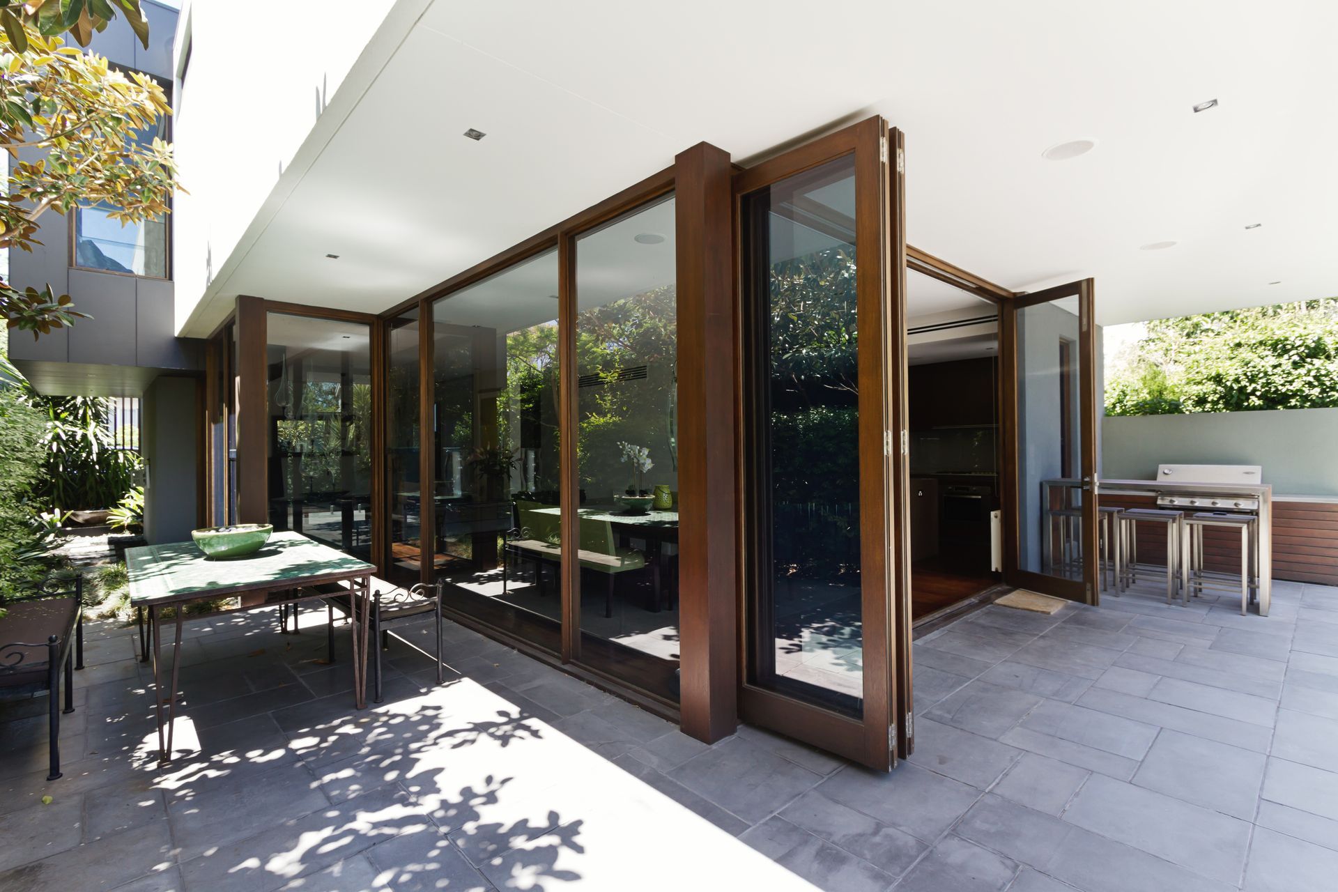 A patio with a table and chairs outside of a house