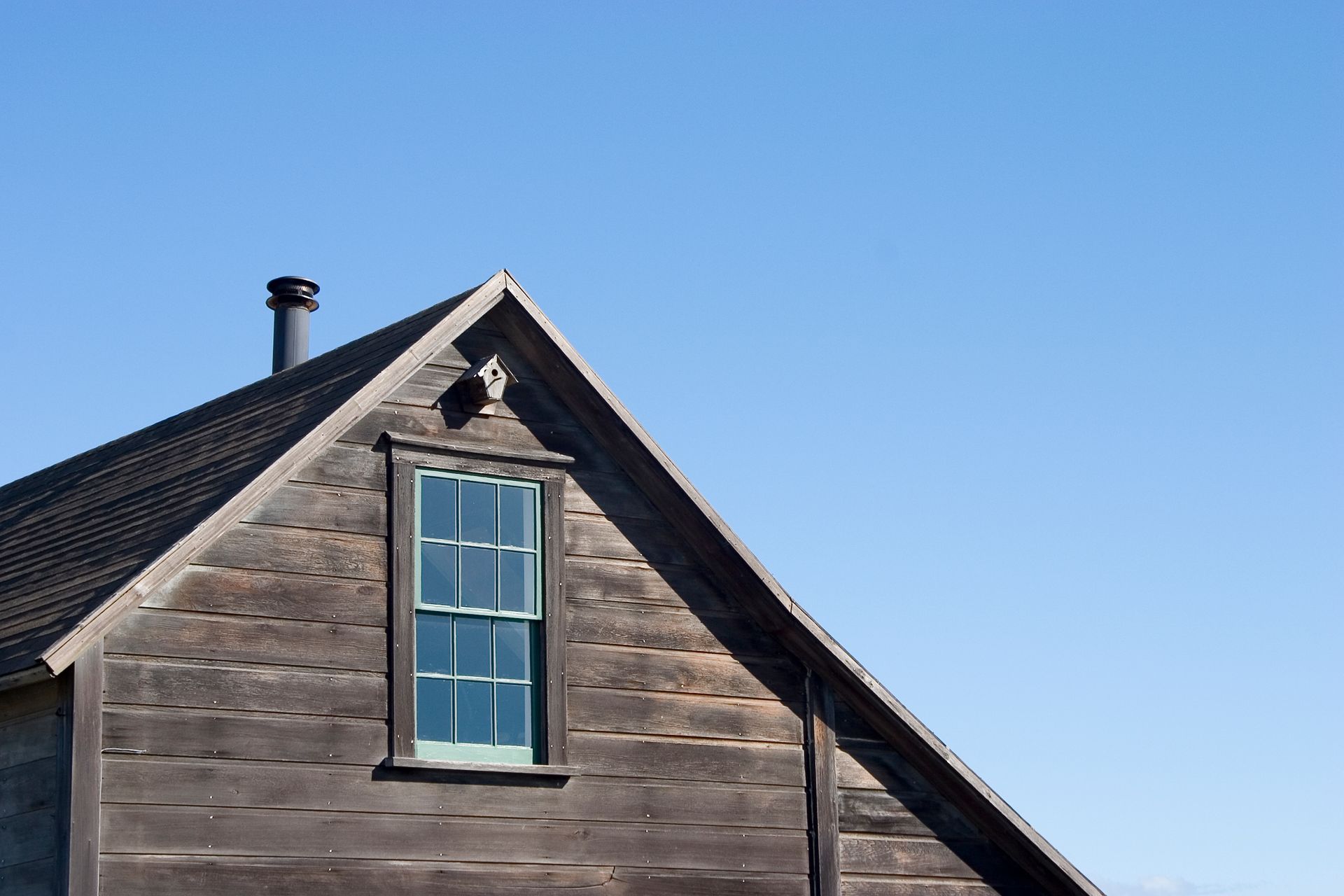 A wooden house with a blue sky in the background