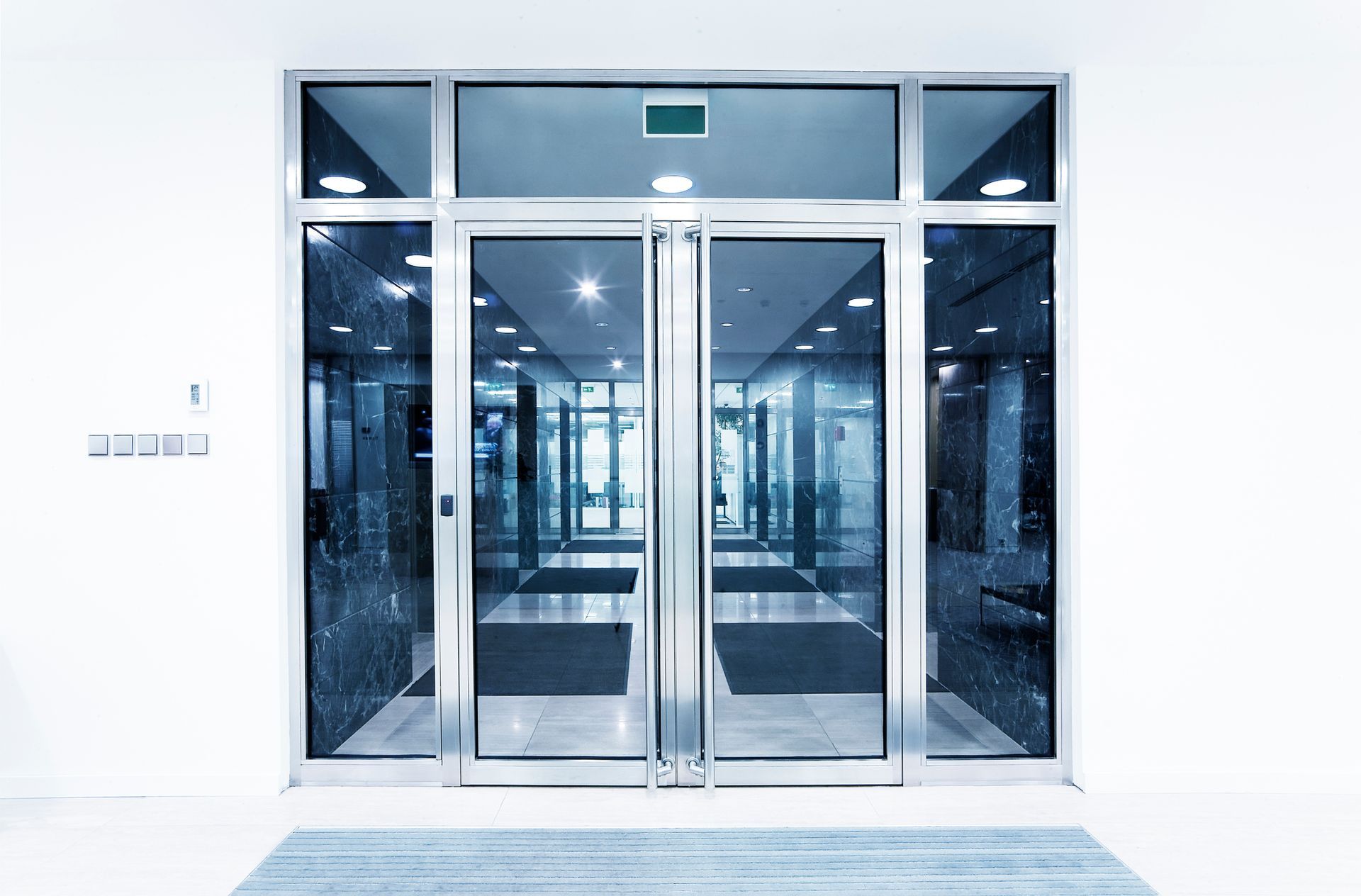 A large glass door in a building with a lot of windows.