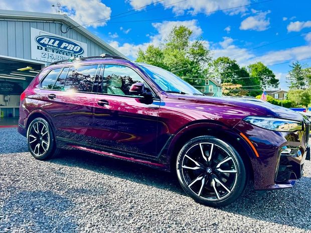 A person is washing a car wheel with foam
