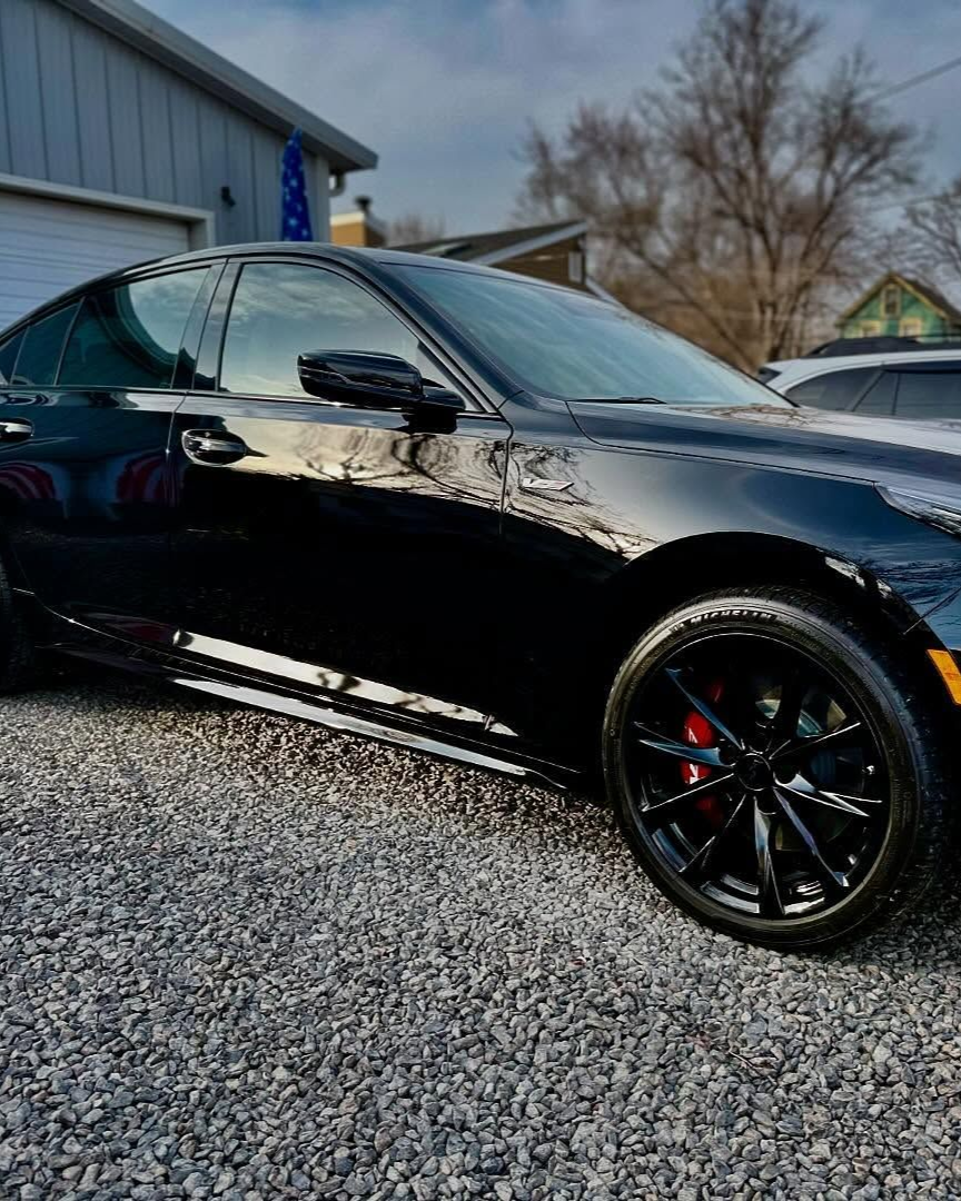 A person is washing a car wheel with foam