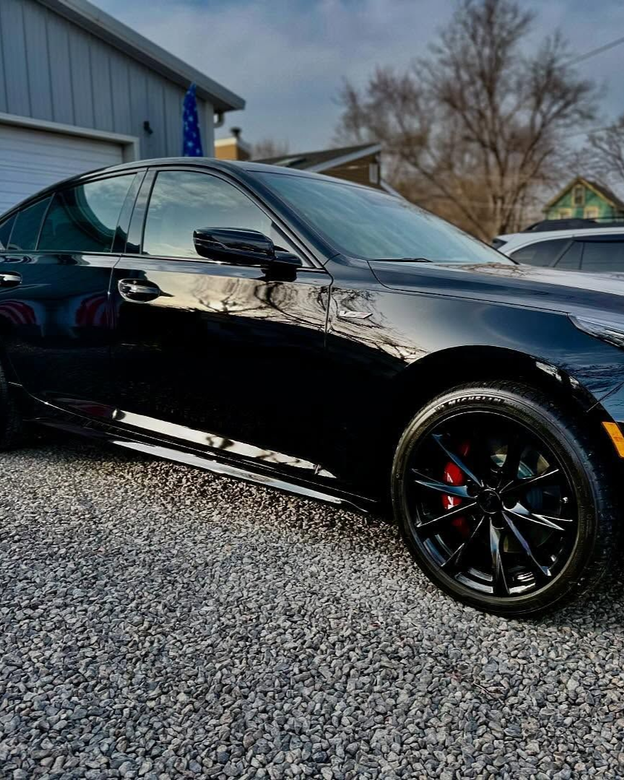A person is washing a car wheel with foam