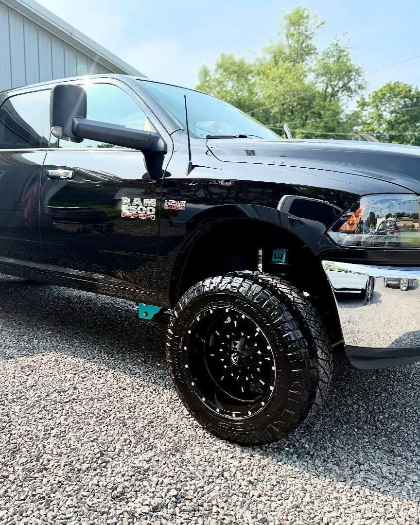 A person is applying a clear film to the hood of a car.