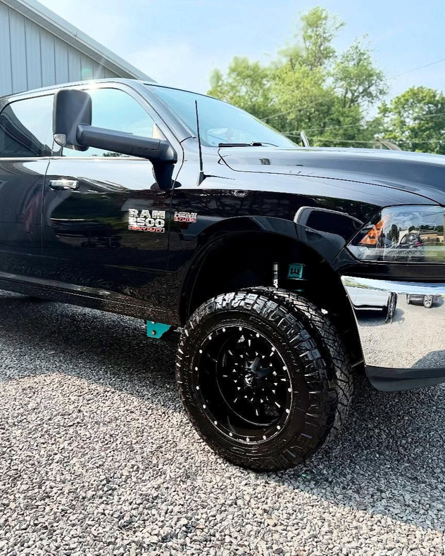 A person is applying a clear film to the hood of a car.
