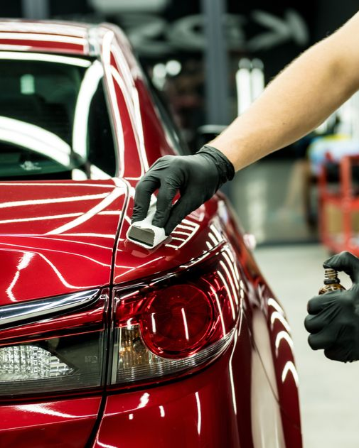 A person is washing a car wheel with foam