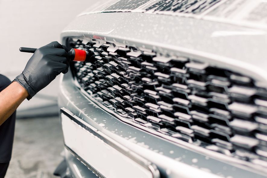 A car is being washed with foam in a garage.