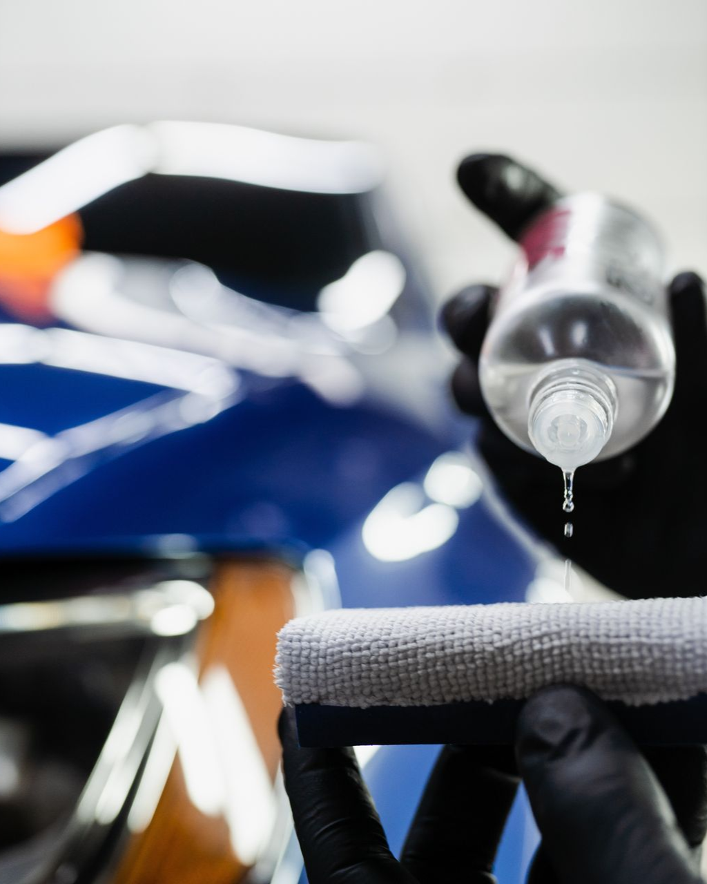 A car is covered in plastic wrap in a garage.